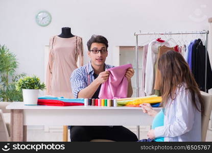 Pregnant woman visiting tailor for new clothing