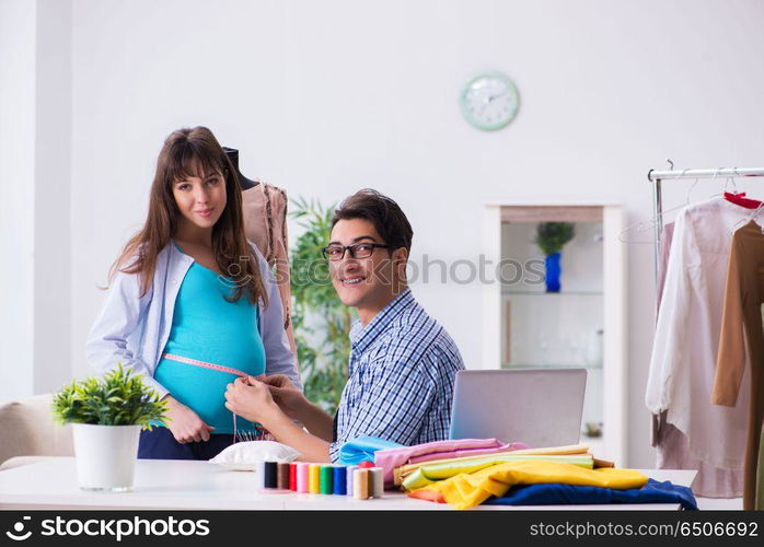 Pregnant woman visiting tailor for new clothing