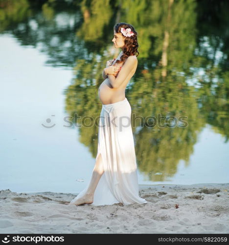 Pregnant woman walking on the beach
