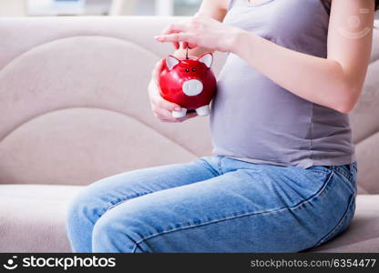 Pregnant woman with a belly tummy sitting on a sofa at home