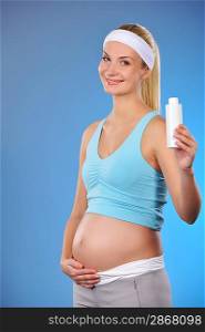 Pregnant woman with a bottle of oil