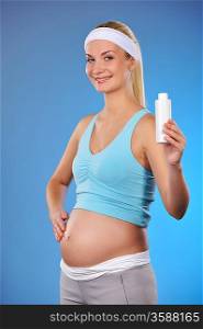 Pregnant woman with a bottle of oil