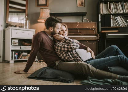 Pregnant woman with a husband sitting on the floor in the room