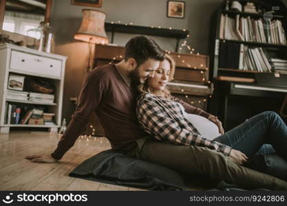 Pregnant woman with a husband sitting on the floor in the room