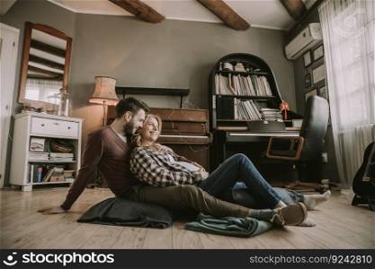 Pregnant woman with a husband sitting on the floor in the room