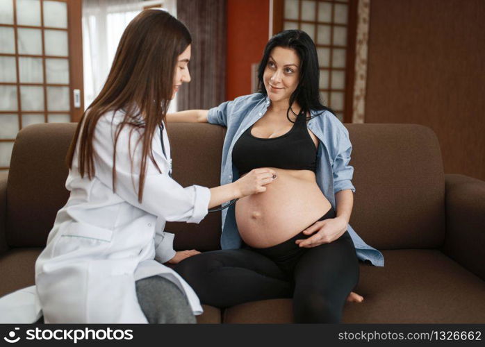 Pregnant woman with belly and a therapist at home. Pregnancy, health care of mother and unborn baby in prenatal period. Expectant mom, healthy lifestyle. Pregnant woman with belly and a therapist at home