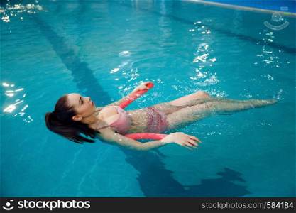 Pregnant woman with big belly swimming in the pool indoors. Pregnancy being, relaxation in the water, recreational exercise for healthcare. Pregnant woman with big belly swimming in the pool