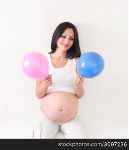 pregnant woman with blue and pink balloon