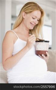 Pregnant woman with bucket of ice cream smiling