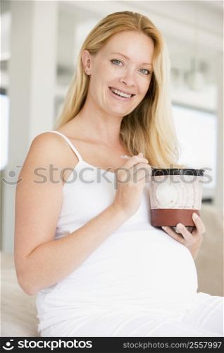 Pregnant woman with bucket of ice cream smiling
