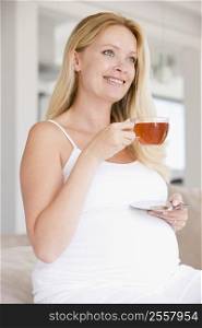 Pregnant woman with cup of tea smiling