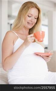 Pregnant woman with cup of tea smiling