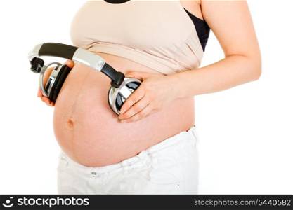 Pregnant woman with headphones on her belly isolated on white. Close-up.&#xA;
