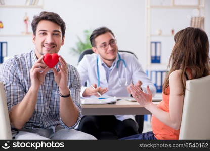 Pregnant woman with her husband visiting the doctor in clinic