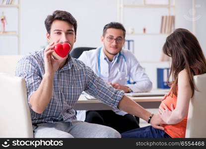 Pregnant woman with her husband visiting the doctor in clinic