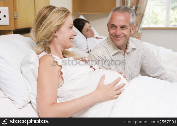 Pregnant woman with husband in hospital smiling