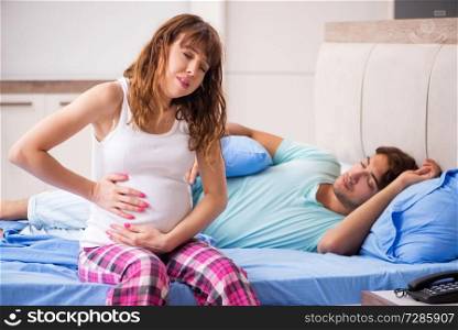 Pregnant woman with husband in the bedroom 