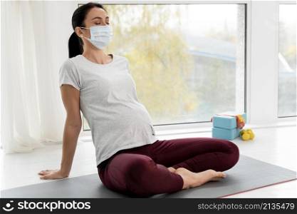 pregnant woman with medical mask relaxing