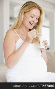 Pregnant woman with yogurt smiling