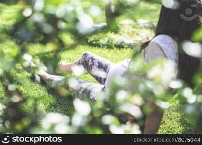 Pregnant women in the garden. Green grass