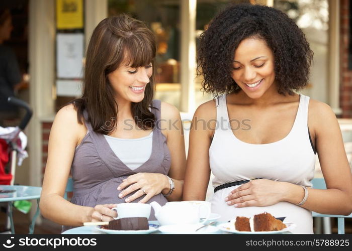 Pregnant women sitting outside cafe