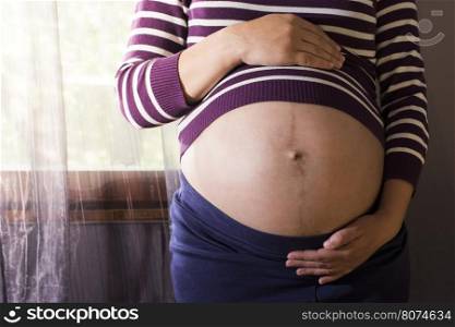 Pregnant women to the window. Violet colors