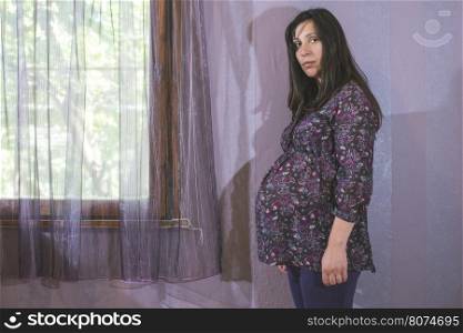 Pregnant women to the window. Violet colors