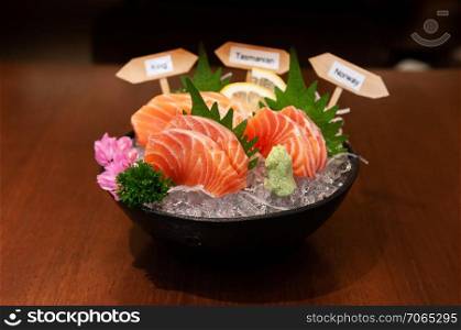 Premium Japanese Salmon Sashimi King Salmon, Tasmanian salmon, Norway salmon on ice in black ceramic bowl.