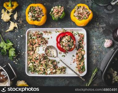 Preparation of bell paprika meat stuffing on rustic kitchen table background with cooking spoon, top view