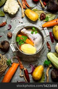 Preparation of fragrant chicken soup with fresh vegetables. On the stone table.. Preparation of fragrant chicken soup with fresh vegetables
