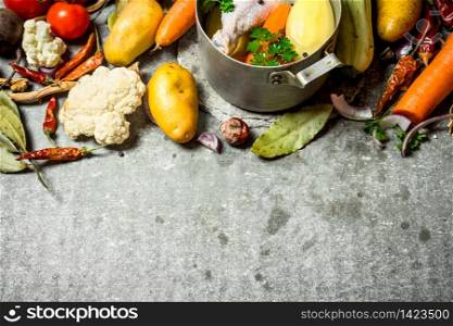 Preparation of fragrant chicken soup with fresh vegetables. On the stone table.. Preparation of fragrant chicken soup with fresh vegetables