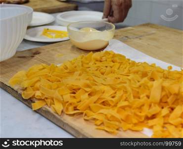 Preparation of Raw Italian Pasta on Wooden Cutting Board