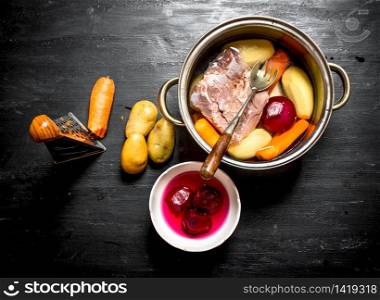 Preparation of soup from fresh vegetables. On a black wooden background.. Preparation of soup from fresh vegetables.