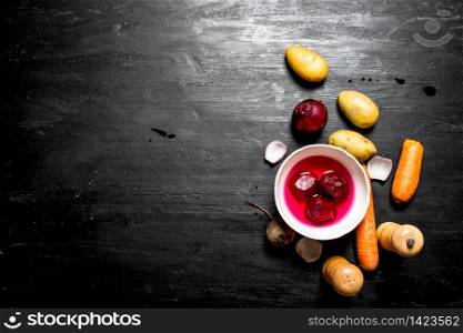Preparation of soup from fresh vegetables. On a black wooden background.. Preparation of soup from fresh vegetables.
