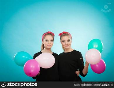 Preparation to birthday party. Two lovely happy retro girls preparing celebration. Smiling joyful women with multicolored balloons.. Retro girls preparing balloons birthday party.