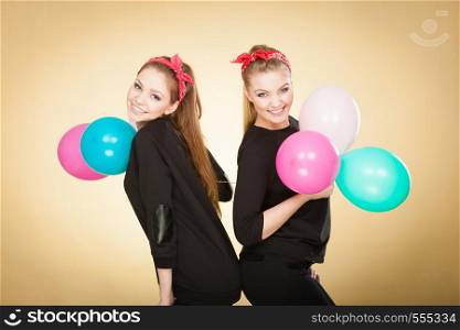 Preparation to birthday party. Two lovely happy retro girls preparing celebration. Smiling joyful women with multicolored balloons.. Retro girls preparing balloons birthday party.