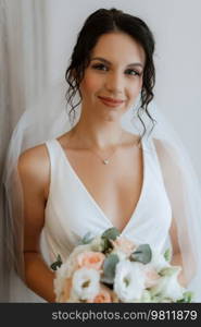 preparations for the bride with the dressing of the wedding dress in the studio