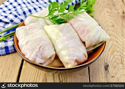 Prepared stuffed cabbage with minced, parsley in a dish, napkin on the background of wooden boards