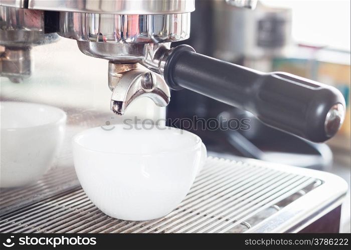 Prepares espresso in white coffee cup, stock photo