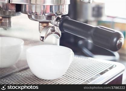Prepares espresso in white coffee cup, stock photo