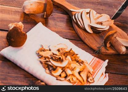 preparing fresh boletus edulis for drying over Wooden Background. Autumn Cep Mushrooms. Cooking delicious organic mushroom. Gourmet food