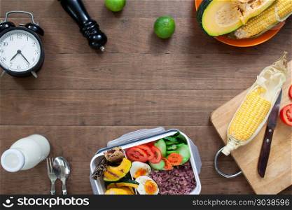 Preparing healthy kitchen frame with lunch box, rice berry, boil. Preparing healthy kitchen frame with lunch box, rice berry, boiled eggs, corn and pumpkin on wooden background, Healthy lifestyle concept