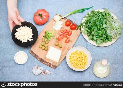 Preparing healthy snacks with fresh cheese and vegetables