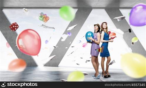 Preparing office party. Two young woman in casual celebrating in office