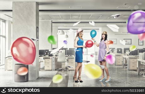 Preparing office party. Two young woman in casual celebrating in office