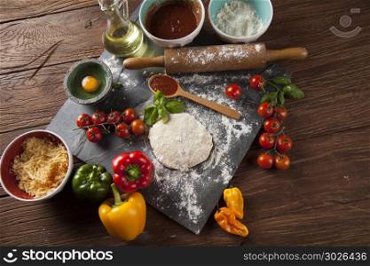 Preparing pizza with dough and tomato sauce. Fresh an tasty homemade pizza preparation