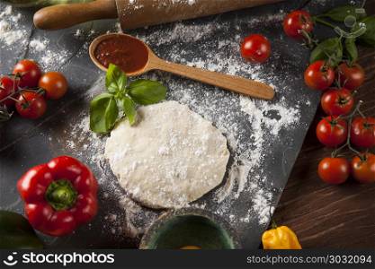 Preparing pizza with dough and tomato sauce. Fresh an tasty homemade pizza preparation