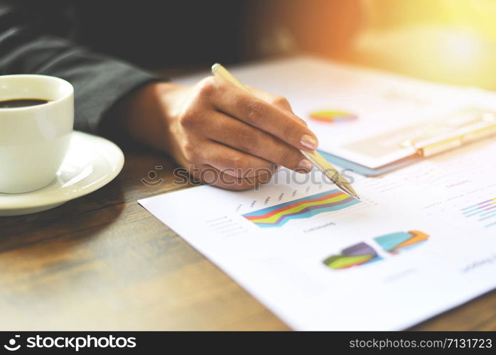 Preparing report money analyzing graphs / Business woman working in office with checking business report on the table desk with coffee cup