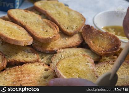 Preparing Slices of Grilled Bread with Olive Oil, Italian Snack.. Preparing Slices of Grilled Bread with Olive Oil, Italian Snack