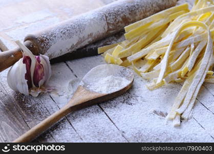 Preparing tagliatelle on wooden table in the kitchen.